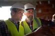© Artcore Studio/Stocksy - Two workers discussing plans on construction site