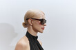 © Serge Filimonov/Stocksy - Profile portrait woman in stylish sunglasses studio background