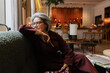 © Angel Santana/Stocksy - Sophisticated Senior woman relaxing in a luxurious hotel lounge