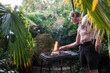 © Luciano Spinelli/Stocksy - Man Grilling in Garden With Plants and Fire