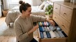 © Pangastuti - Woman smiling organizing clothes in wooden dresser drawer