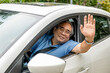 © Marc Tran/Stocksy - happy an older man open window of a car and raising his hand