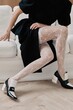 © Serge Filimonov/Stocksy - Anonymous woman sit on sofa - Fashion detail