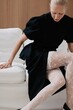 © Serge Filimonov/Stocksy - Contemporary fashion portrait of woman sit on sofa
