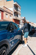 © Santi Nuñez/Stocksy - Young woman with leg prosthesis opening car door