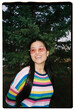 © Azamat Mukanov/Stocksy - Smiling Woman in Colorful Sweater and Sunglasses Outdoors