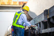 © JU.STOCKER - Logistics manager inspecting safety tag on freight train cargo wagon at railyard, Railway inspector and engineer checking industrial rail tanker car for quality control and safety compliance