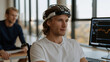 © forenna - Paralympic athlete mentally composing text message using only brainwave-based brain-computer interface, sports physiotherapist reviewing neural activity log on adjacent monitor, rehabilitation sport
