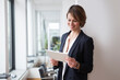 © Westend61 - Smiling businesswoman holding digital tablet in office