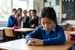 © Olga Ко - Sad Asian schoolgirl suffering from school bullying and racial discrimination, sitting alone while classmates whisper and gossip in the blurred background