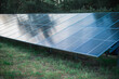© illustrissima - A small solar panel farm for generating eco-electricity on the edge of a forest in a recreation area at the base. Renewable energy, eco-friendliness, and environmental safety.