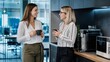 © INTAN - Two Professional Businesswomen Having Coffee Break and Talking in Modern Office Kitchen