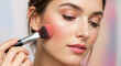 © NeuroCake - Young woman applying pink blush with a makeup brush. Soft pastel makeup concept