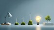 © jiratip - Conceptual representation of energy transition and innovation. A desk lamp is followed by three miniature wind turbines on grassy mounds, a glowing lightbulb, and a miniature tree atop books.