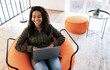 © Prostock-studio - Happy African American Woman Using Laptop Wearing Wireless Headphones Typing On Keyboard Working Or Studying Online At Home. Freelancer Lady Browsing Internet Sitting On Pouf Chair, High Angle View