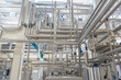 © Dragan - Modern industrial factory interior with stainless steel pipes and processing machinery. Clean automated production line in food, dairy, or chemical plant engineering industry.