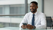 © huaomanz - Successful Black Financial Consultant in High-End Workspace