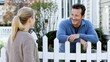 © FAQIH - Friendly Neighbors Chatting Over a White Picket Fence in Suburban Yard