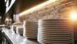 © Fariz - Stacks of clean white plates ready for service, bathed in warm light