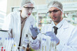 © winnievinzence - Professional male and female scientists in lab coats and PPE examining samples in petri dish, conducting medical research and clinical experiments in modern laboratory for biotechnology development