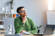 © Prostock-studio - Focused Caucasian Man In Green Shirt Thinking While Working On Laptop At Modern Office, Sitting At Desk With Notebook And Glass Of Water. Inspiring Business Concept
