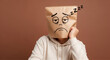 © ViskBx - Person with a paper bag on their head with a sleepy face drawing, expressing exhaustion, boredom, or lack of sleep on brown background