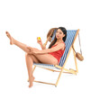 © Pixel-Shot - Beautiful young woman applying sunscreen cream in deck chair on white background