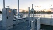 © Юлия Сергеева - Water treatment facility with control panels and pipelines at sunset near a river