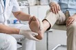© Lisicus - Woman doctor examining elderly man foot ulcer. Treating diabetic wound on heel. Medical healthcare concept for geriatric care