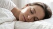 © LinearAndLoom - Close-Up of Serene Young Woman Sleeping Peacefully in White Bed