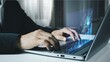© AndriHernawan - Side view of corporate businessman typing on laptop keyboard with glowing transparent digital financial graph bar projection chart
