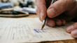 © logonv - Man writing with pen on paper document form. Close up of male hand filling information on grid sheet. Administrative task, accounting and business paperwork process. Office work concept.