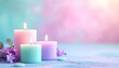 © Nam - Pastel Scented Candles Burning Beside Purple Flowers on Soft Spa Background