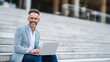 © sup - Man using laptop on concrete steps
