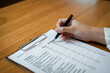 © Lahmz - Person filling mental health checklist on clipboard with pen, psychological assessment, self evaluation, healthcare screening and wellbeing awareness concept.