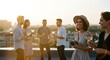© Benjamin - Friends socializing with wine glasses on rooftop at sunset