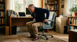 © INT888 - Senior man standing up struggle office chair back pain home office elder man struggling to stand up from office chair home office, gripping armrest with discomfort, health concept, warm daylight