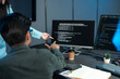 © Jestercine - Developers Pointing At Code On Monitor In Dark Office
