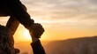 © LK - Two people holding hands on a mountain top at sunset