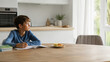 © garpinina - boy studying alone at kitchen table during parents divorce and absence