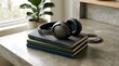 © Huzaifa - A pair of black headphones sitting on top of a stack of books on a concrete table next to a potted plant