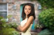 © BillionPhotos.com - Smiling young Black woman standing with arms crossed outside a stone house