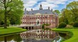 © Store - a large red brick building with a reflection in a pond surrounded by green grass and trees on a sunn