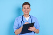 © New Africa - Medical assistant with clipboard on light blue background