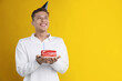 © New Africa - Man holding piece of cake with burning candle on orange background, space for text