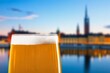 © BillionPhotos.com - Beer glass with foam standing against a blurred Stockholm city skyline at twilight in Sweden
