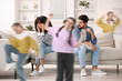 © New Africa - Family with hyperactive children. Kids having fun while tired parents sitting on sofa