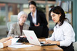 © JackF - Young woman works on her laptop in group of women of different ages in office space