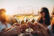 © oksa_studio - Friends toasting white wine glasses at summer sunset party cheers celebration lifestyle