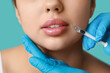 © Pixel-Shot - Young woman receiving lip injection on color background, closeup